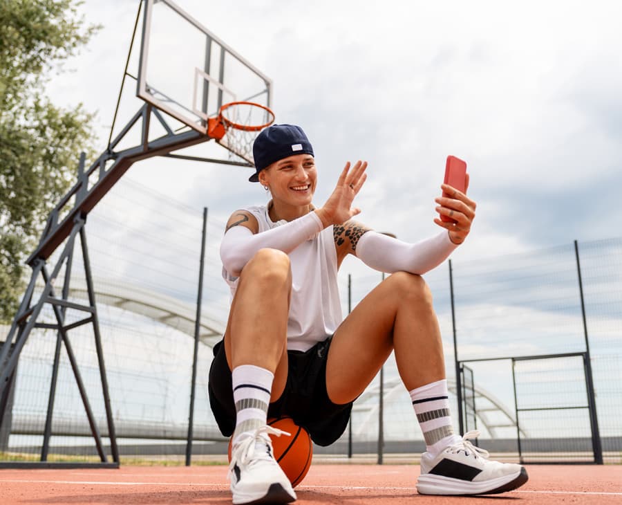 An athlete records a video response on a phone outdoors